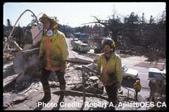Two OES firefighters inspect homes lost in a fire.