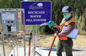 An image of a person at a recycled water fill station.